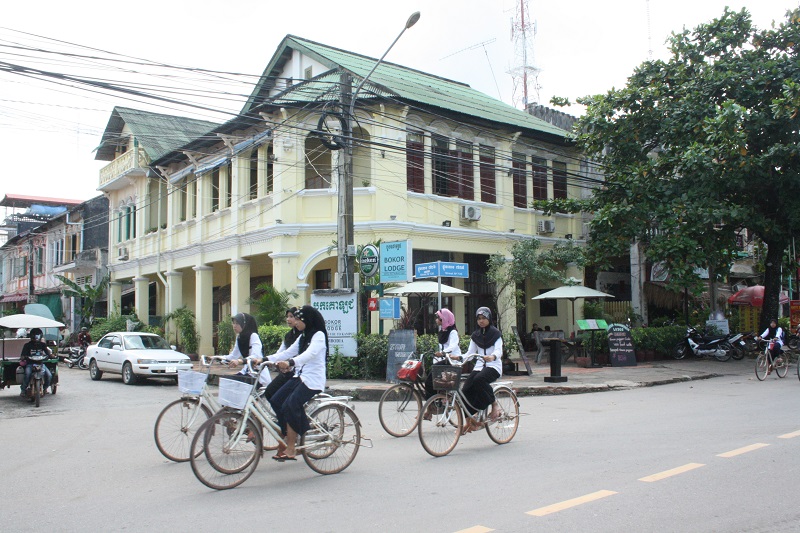 Cambodja verkeer, schoolmeisjes op de fiets in Kampot